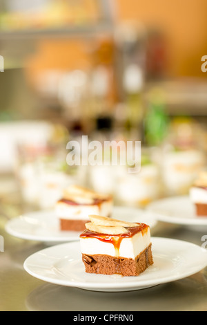 Bananendessert auf weißen Teller in Cafeteria Mensa leckeren Kuchen Stockfoto