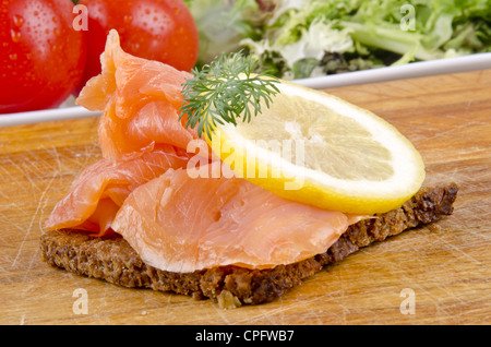 wilde Lachsscheiben mit Zitrone auf Roggenbrot Stockfoto