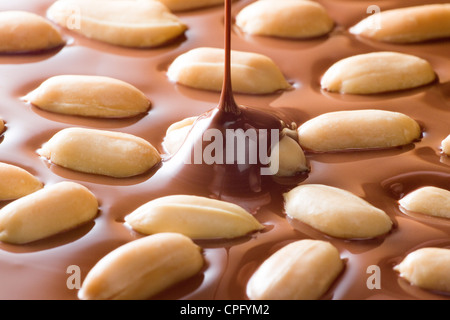 Schokolade fallen auf Erdnüsse Stockfoto