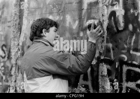 Ein junger Mann ausschlagen Teile der Mauer, Berlin, Deutschland Stockfoto