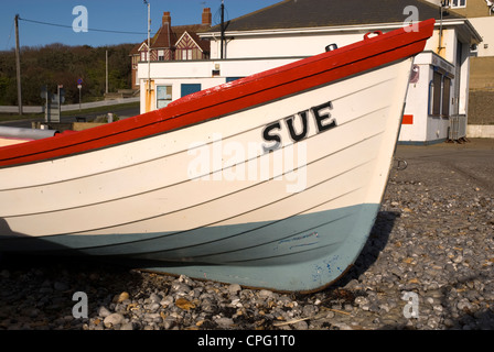 Ein kleines Ruderboot named SUE auf einem Kiesstrand Stockfoto