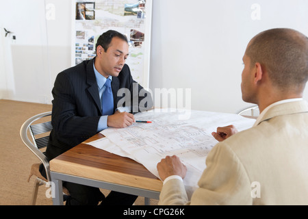 Zwei Geschäftsleute diskutieren über Blaupause. Stockfoto