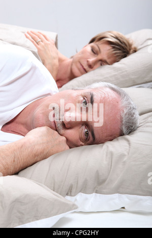 ein Mann ist wach, wenn seine Frau schläft Stockfoto