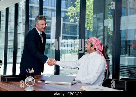 Arabische Geschäftsmann und westliche Geschäftsmann Händeschütteln im Büro. Stockfoto