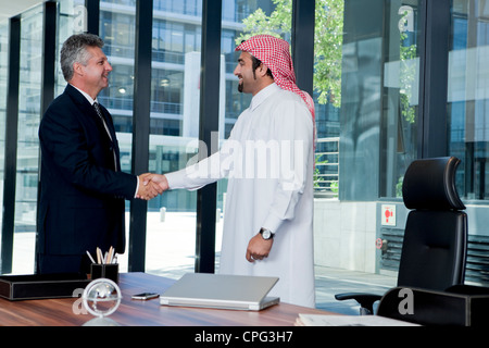 Arabische Geschäftsmann und westliche Geschäftsmann Händeschütteln im Büro. Stockfoto