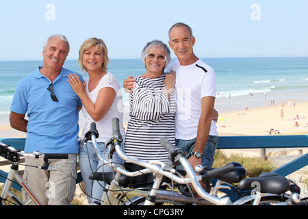 Porträt von vier Personen am Strand mit Fahrrädern Stockfoto