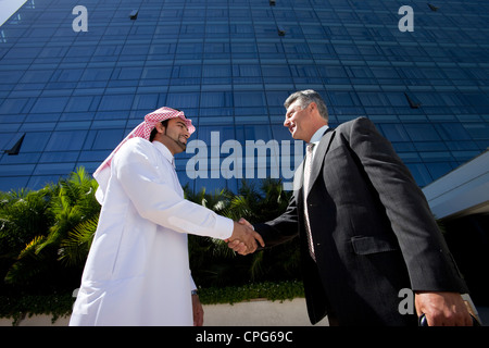 Arabische Geschäftsmann und westliche Geschäftsmann Händeschütteln vor der Bürogebäude. Stockfoto