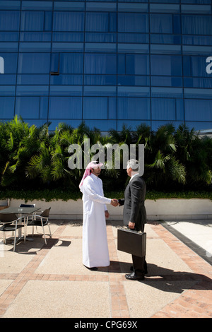 Arabische Geschäftsmann und westliche Geschäftsmann Händeschütteln vor der Bürogebäude. Stockfoto