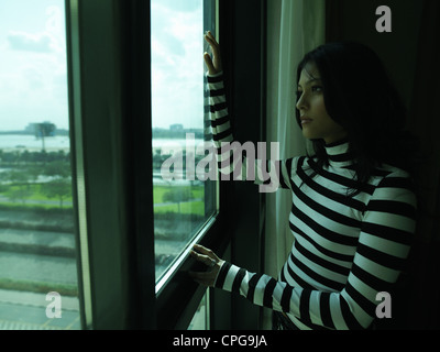 Junge Dame schaut aus dem Fenster. Stockfoto