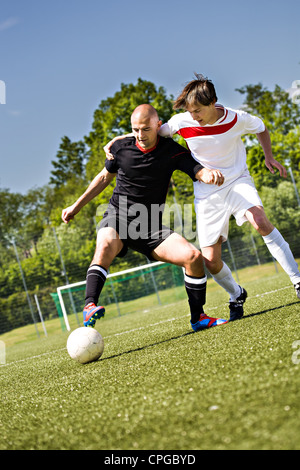 zwei Fußballspieler vom gegnerischen Team auf dem Feld Stockfoto