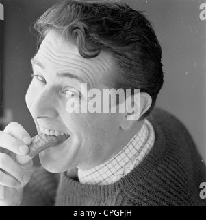 Werbung nach wie vor von sechziger Jahre zeigt einen Gentleman ein Schokolade Keks essen. Stockfoto