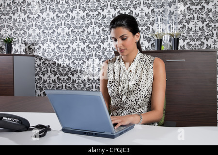 Geschäftsfrau am Schreibtisch mit Laptop. Stockfoto