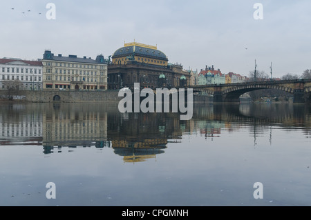 Das Nationaltheater Prag, Tschechische Republik. Spiegelt sich in den noch winterlichen Gewässern des Flusses Vltava (Moldau) Stockfoto