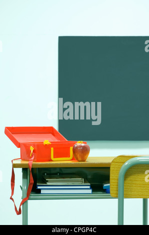 Tiffin Box und Apple gehalten auf Schreibtisch im Klassenzimmer Stockfoto