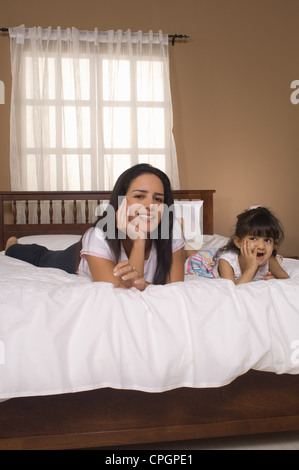 Tochter (3-4) mit Mutter am Bett liegen Stockfoto