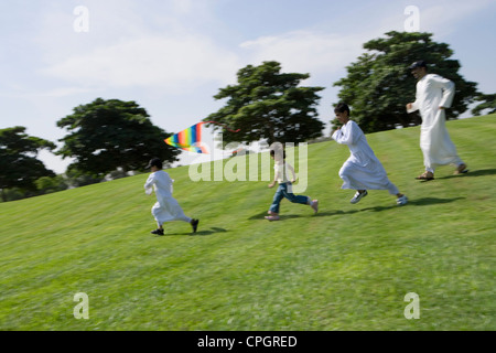 Vater und Kinder spielen im park Stockfoto
