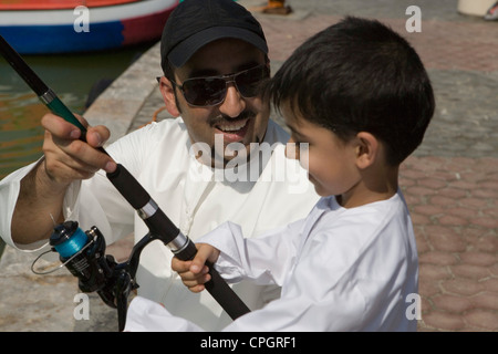 Vater mit Sohn halten, Angelrute, lächelnd, Nahaufnahme Stockfoto
