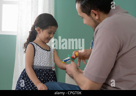 Vater und Tochter zu Hause Mann vorgibt, dem Mädchen ein Schuss Stockfoto