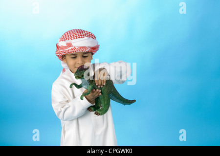 Arabische Jungen spielen mit Spielzeug Dinosaurier Stockfoto