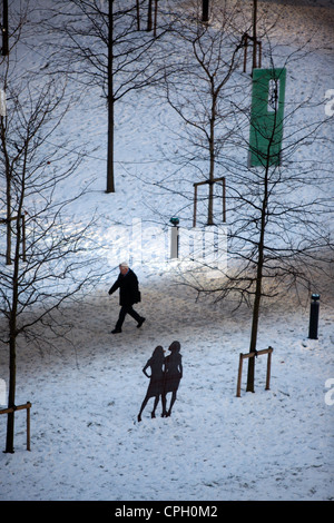 Ein Mann geht durch Schnee auf dem Weg zu seinem Arbeitsplatz im Spinningfileds Hardman Boulevard Manchester Stadtzentrum Stockfoto