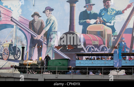 Replik von Planet Steam train im Museum of Science and Industry Manchester UK vorbei an großen Löwen-Wandbild mit Stephensons Rocket Stockfoto