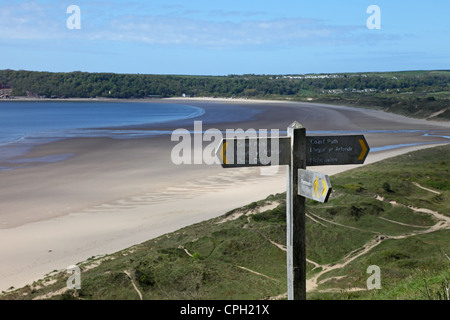 Küsten-Wanderweg-Zeichen zu Nicholaston und drei Klippen Bucht mit Oxwich Bucht hinter Gower South Wales UK Stockfoto