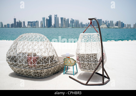 Moderne Sitzgelegenheiten im Freien an der Waterfront Cafe mit Blick auf die Skyline von Doha in Katar