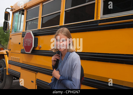 Middle School Student lächelnd vor ihr Schulbus. Stockfoto