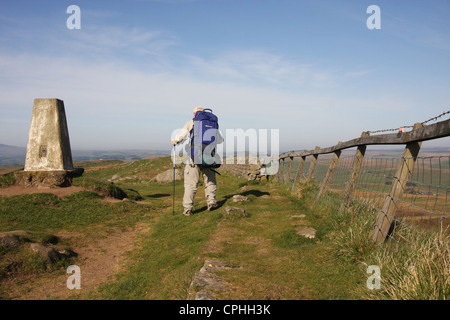 Wanderer zu Fuß entlang der Hadrianswall entlang der höchste Punkt an Windschutzscheibe Felsen. Stockfoto