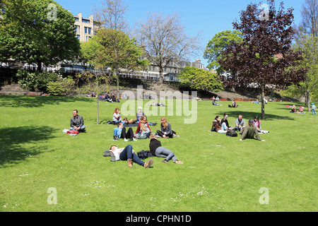 Junge Leute genießen den Sonnenschein in Princes Street Gardens, Edinburgh Scotland UK Stockfoto