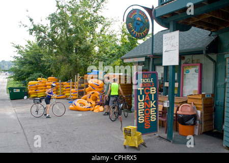 Radfahrer in Anbetracht der große Röhren für schwimmende stromabwärts Wurzel bei Root River Outfitters. Lanesboro Minnesota MN USA Stockfoto