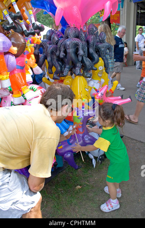 Papa hilft Tochter Lila Einhorn von Ballon-Souvenir-Stand zu wählen. Minnesota State Fair St. Paul Minnesota MN USA Stockfoto