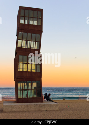 BARCELONA, Spanien - Dezember 2011: Menschen zu Fuß oder Erholung am berühmten Strand von Barceloneta am Abend in der Nähe von moderne Kunstskulptur. Stockfoto