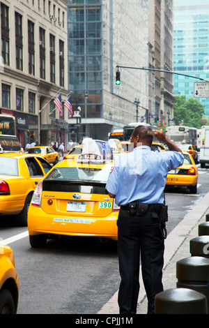 New York City Polizist seine Haare zu kämmen, als berühmten gelben Taxis vorbei Stockfoto