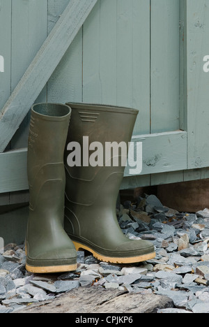 Paar grüne Wellington Stiefel außen ein Gerätehaus. Stockfoto