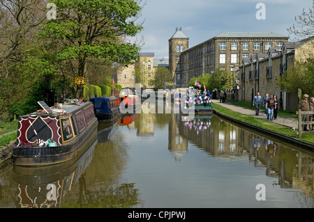 Canal Narrow Boats Barges und Menschen, die auf dem Schleppweg Leeds und dem Liverpool Canal Waterway in der Nähe von Skipton North Yorkshire Dales England Großbritannien laufen Stockfoto