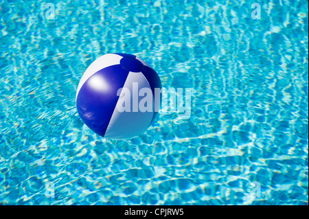 Schwebende blaue und weiße Beachball im Schwimmbad Stockfoto