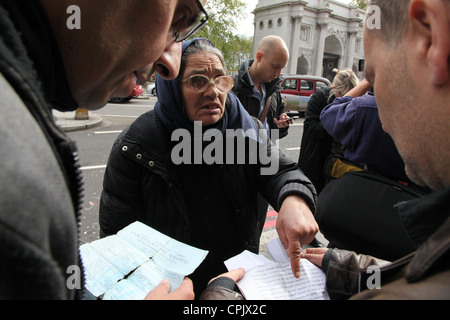 Eine Frau Dokument werden von Grenzbeamten Kontrolle im Londoner West End geprüft. Sie wurde gesehen, um Geld betteln. Stockfoto