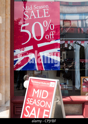 50 % Rabatt auf Verkaufsposter in Edinburgh Woolen Mill Schaufenster in Exeter, Devon, England Stockfoto