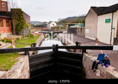 Vater und Kind sitzt am Kanal, teilweise fertigen Cotswold Kanäle Projekt, Stroud, Gloucestershire, Großbritannien Stockfoto