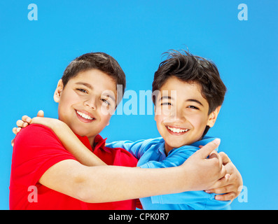 Süße Jungs lächelnd über blauen Himmel Preteens spielen im Freien, Kinder Hand in Hand, umarmen beste Freunde, schöne Kinder Spaß Stockfoto