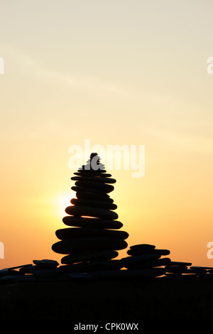 Gestapelten Steinen Silhouette gegen einen Sonnenuntergang. UK Stockfoto