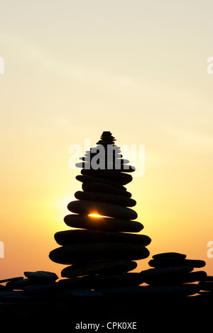 Gestapelten Steinen Silhouette gegen einen Sonnenuntergang. UK Stockfoto