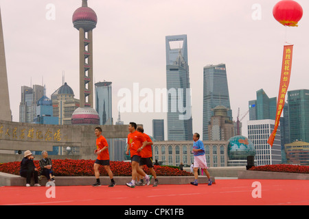 Menschen Joggen am Morgen auf den Bund, Pudong-Skyline im Hintergrund, Shanghai, China Stockfoto