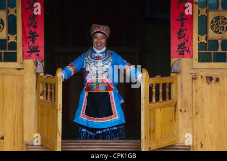 Xijia Frau in traditionellen Kostümen durch die Tür, Kaili, Guizhou, China Stockfoto