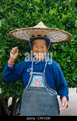 Ältere Xijia-Frau in traditioneller Tracht mit Bambushut, Shilongzhai, in der Nähe von Kaili, Guizhou, China Stockfoto