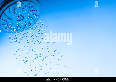 Duschkopf mit Tröpfchen Wasser, blauer Hintergrund Stockfoto