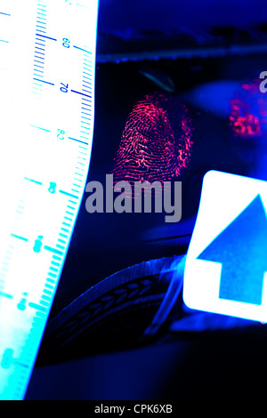 Tatort Fingerabdruck auf einem Messer in einer Forensischen fluoreszierenden Pulver hervorgehoben und mit einem fluoreszierenden UV-Lichtquelle durch ein CSI beleuchtet Stockfoto