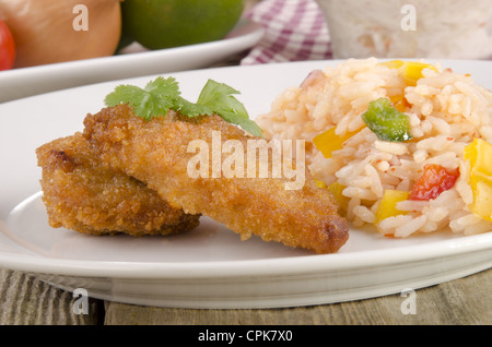 Panierte Chicken Nuggets mit Reissalat auf einem Teller Stockfoto