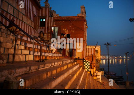 Beim Sonnenaufgang über dem Ganges gebadet werden die Ghats in warmes Sonnenlicht, Varanasi, Uttar Pradesh, Indien Stockfoto